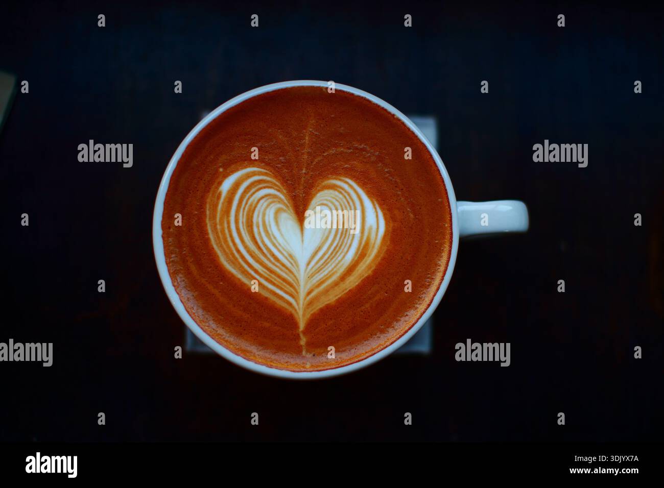 Tazza di latte con latte art a forma di cuore Foto Stock