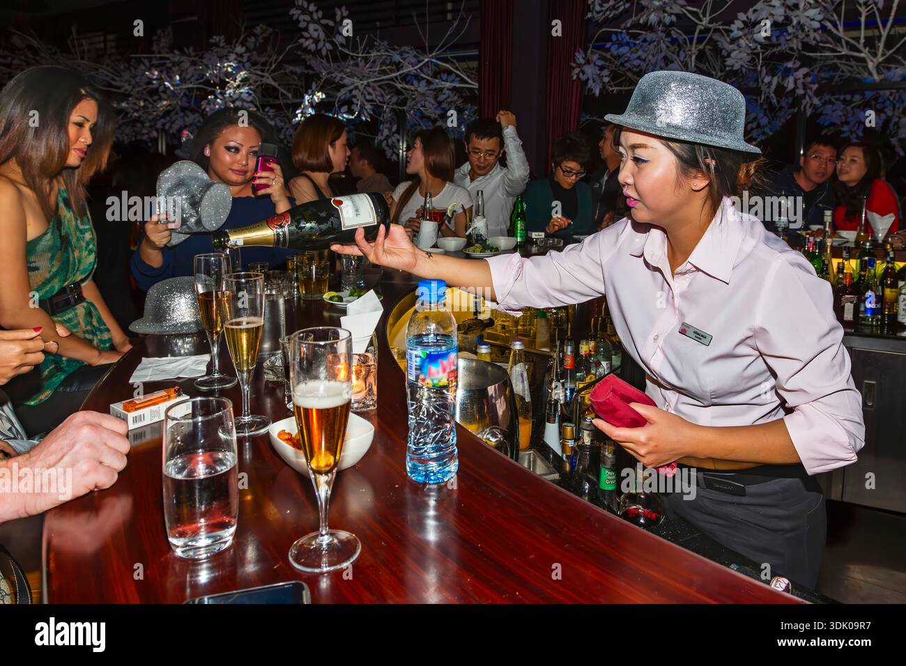 Barista che serve champagne a persone che bevono, festeggiano e si godono la festa di Capodanno, Rooftop Bar, Pacific Place, Hanoi, Vietnam Foto Stock