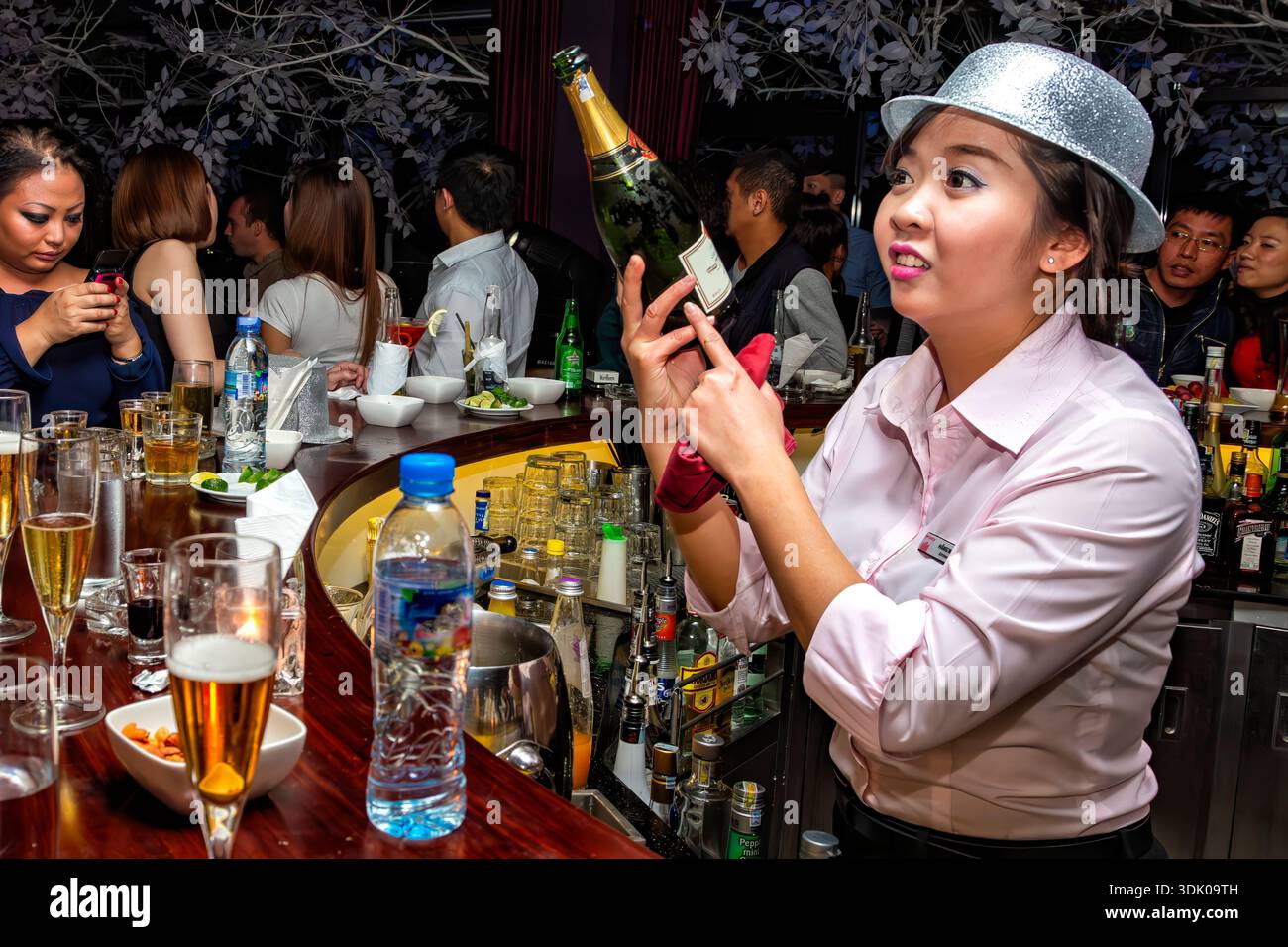 Barista che serve champagne a persone che bevono, festeggiano e si godono la festa di Capodanno, Rooftop Bar, Pacific Place, Hanoi, Vietnam Foto Stock