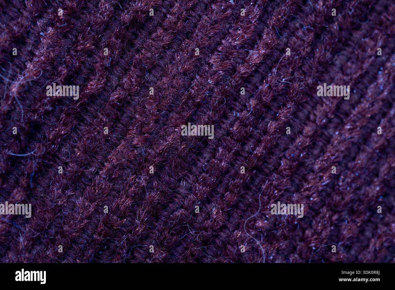 Primo piano del materiale in maglia di lana marrone. Mostra i motivi tessili dettagliati e le fibre di tessuto morbido per la moda o l'artigianato. Foto Stock