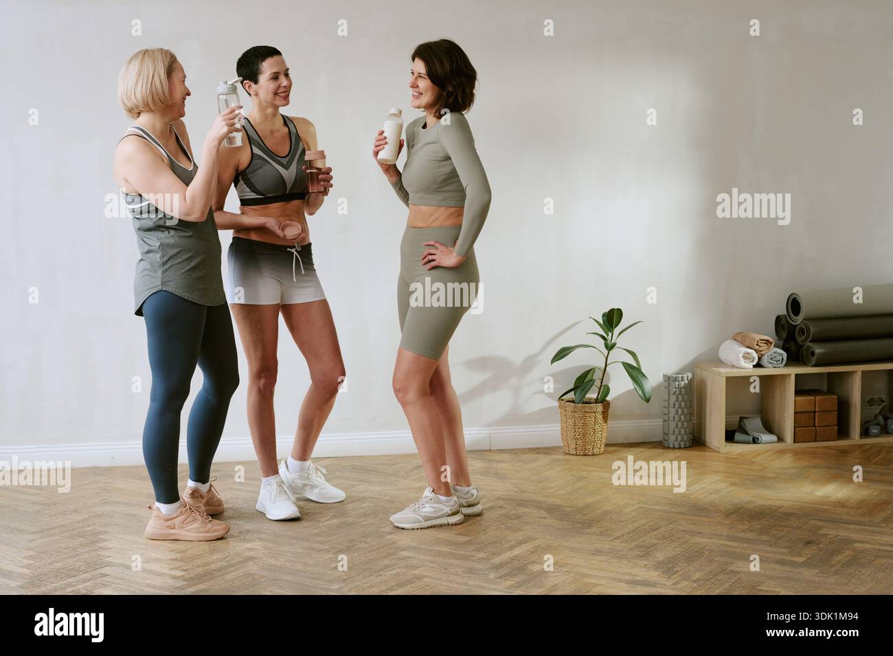 Tre giovani donne adulte socializzano dopo l'allenamento nel fitness Studio Foto Stock