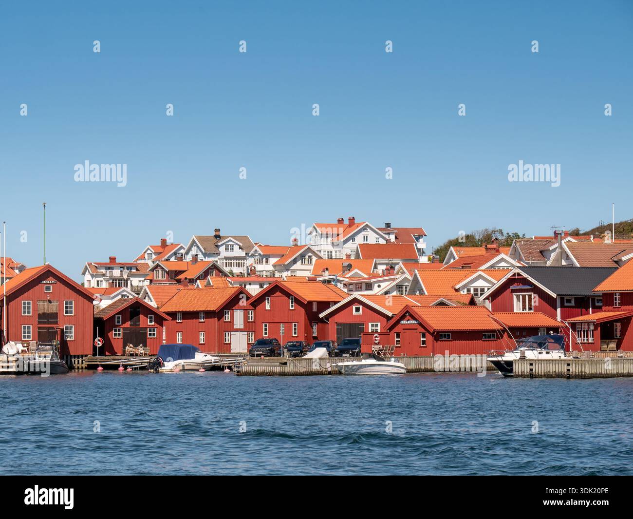 Tradizionali case in legno rosso sul lungomare, ex capanne di pesca e boatouses nel villaggio di Mollösund, nell'arcipelago di Bohuslän, sulla costa occidentale della Svezia Foto Stock