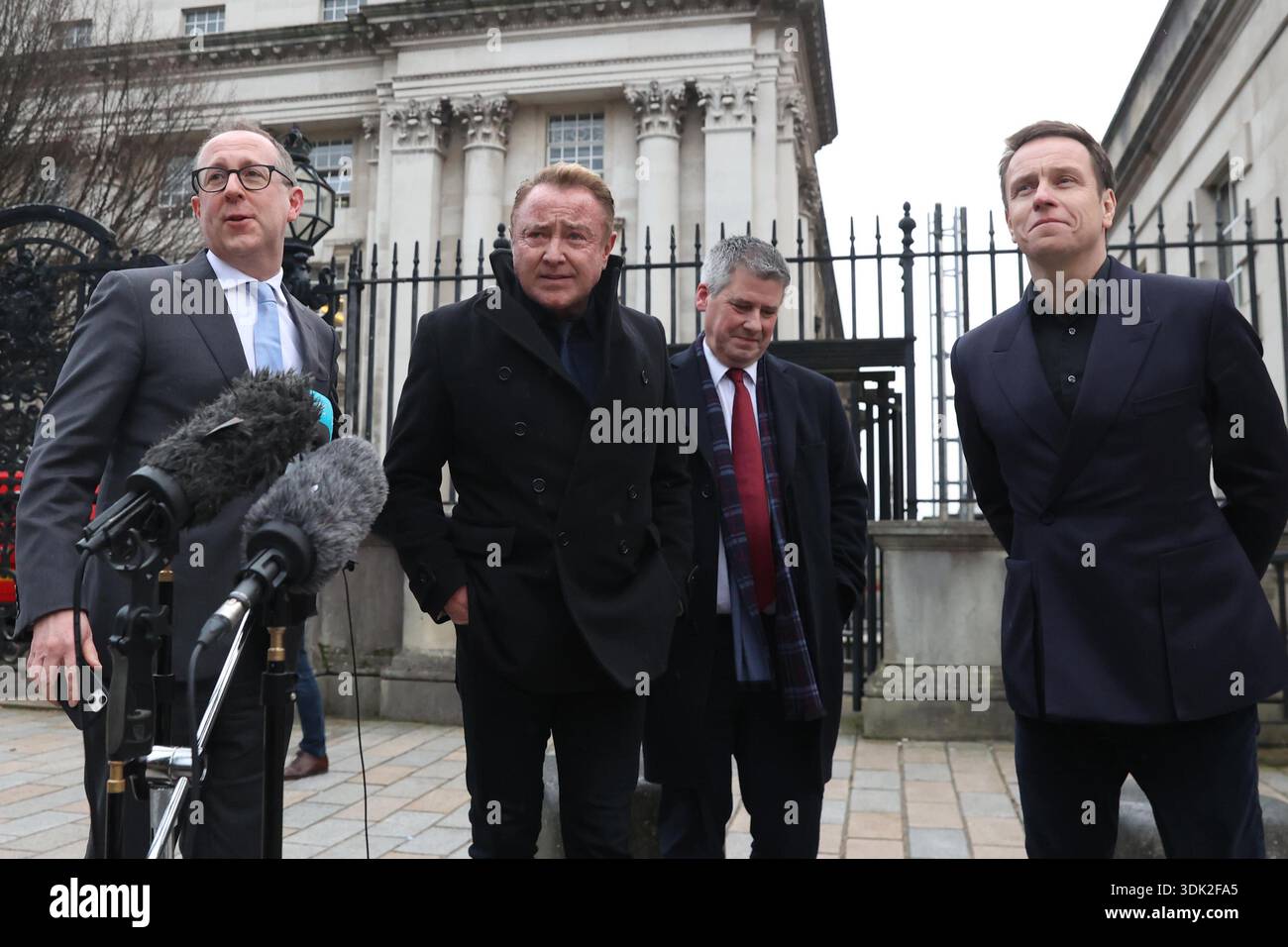 Michael Flatley (second from left) speaking to members of the media outside Belfast High Court, after a legal order blocking him from engaging with the Lord of the Dance production has been overturned. At The Chancery Court in the Royal Courts of Justice on Thursday, Mr Justice Simpson discharged a temporary injunction that had been secured against the dancer and choreographer. Picture date: Thursday January 29, 2026. Foto Stock