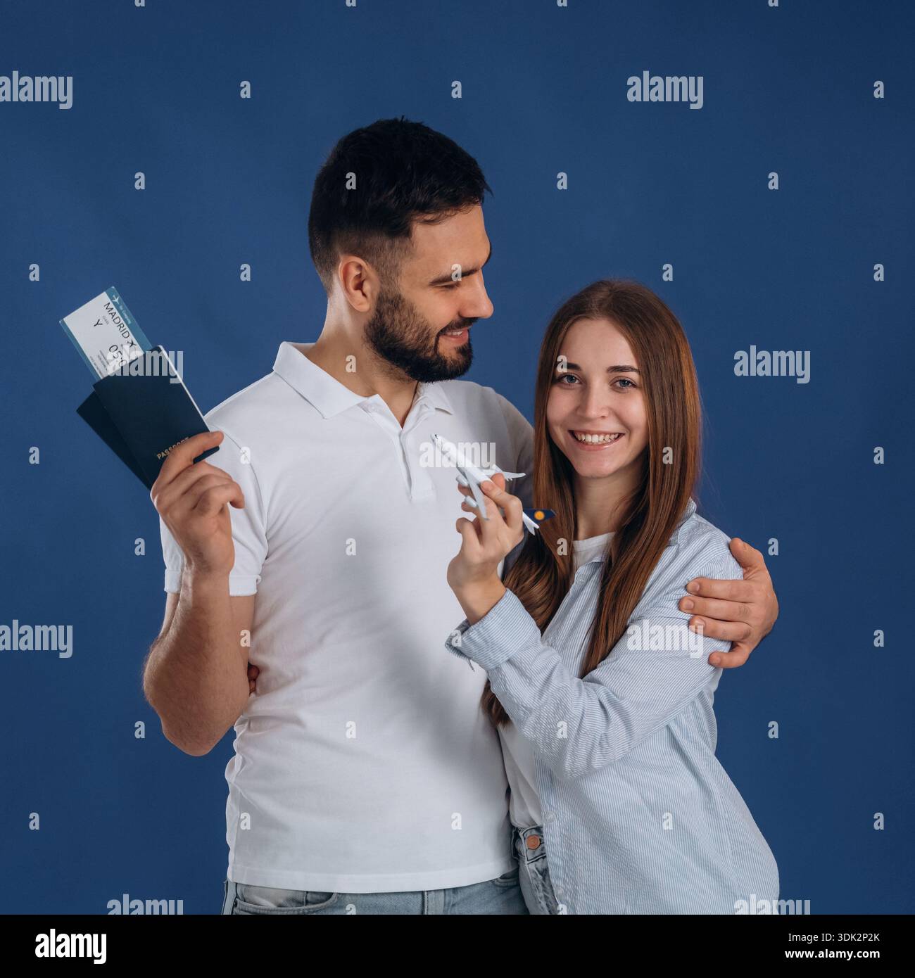 In piedi e sorridendo. Le coppie sono pronte a viaggiare, con i biglietti. Foto Stock