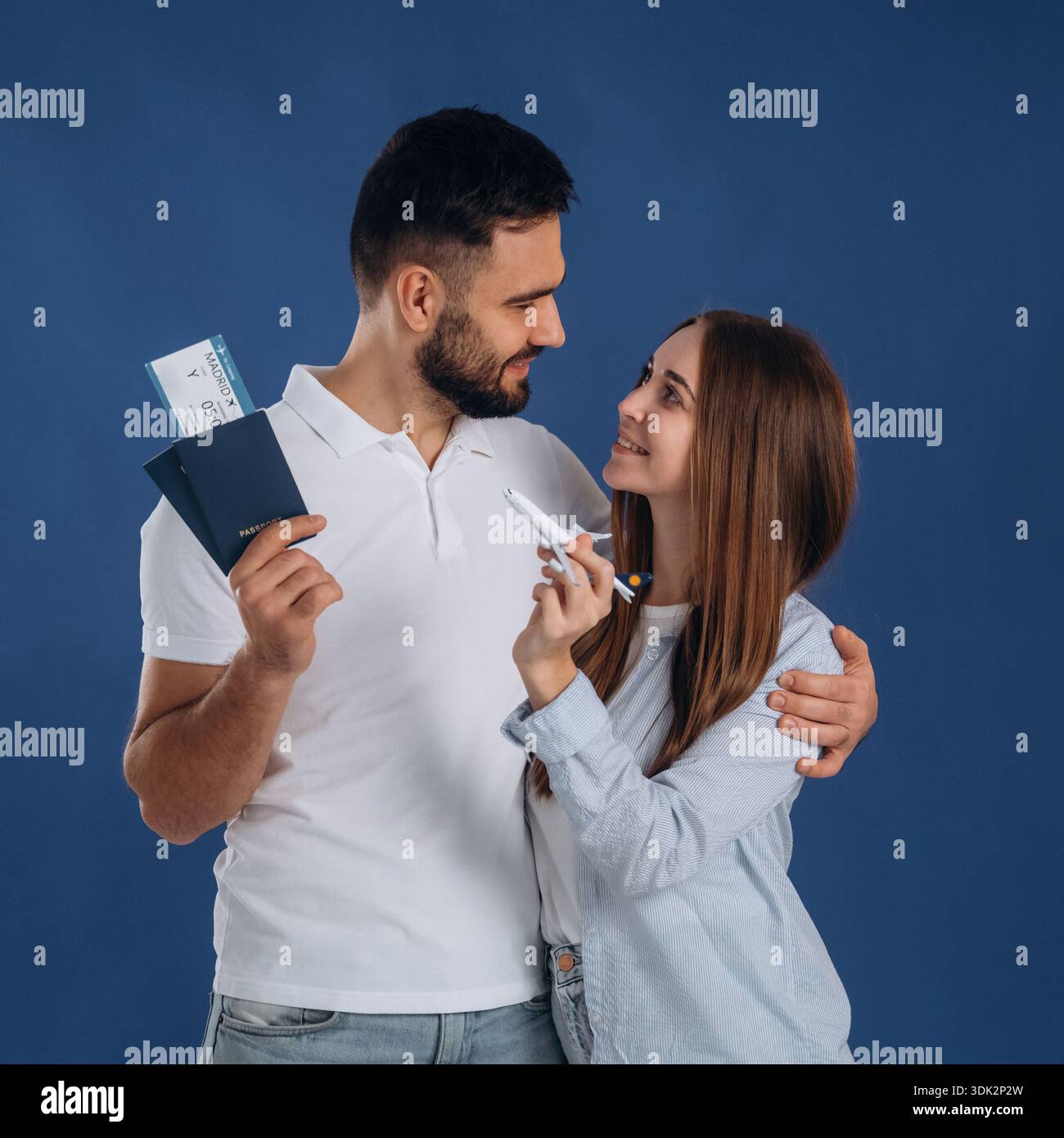 In piedi e sorridendo. Le coppie sono pronte a viaggiare, con i biglietti. Foto Stock