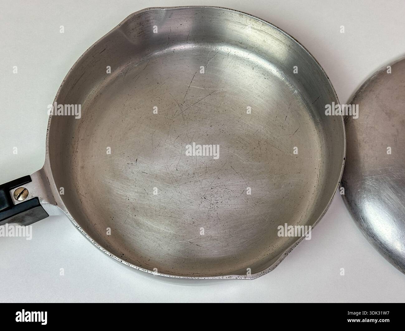 Padella vintage in alluminio, vuota su sfondo chiaro - Immagine stock catturata con smartphone