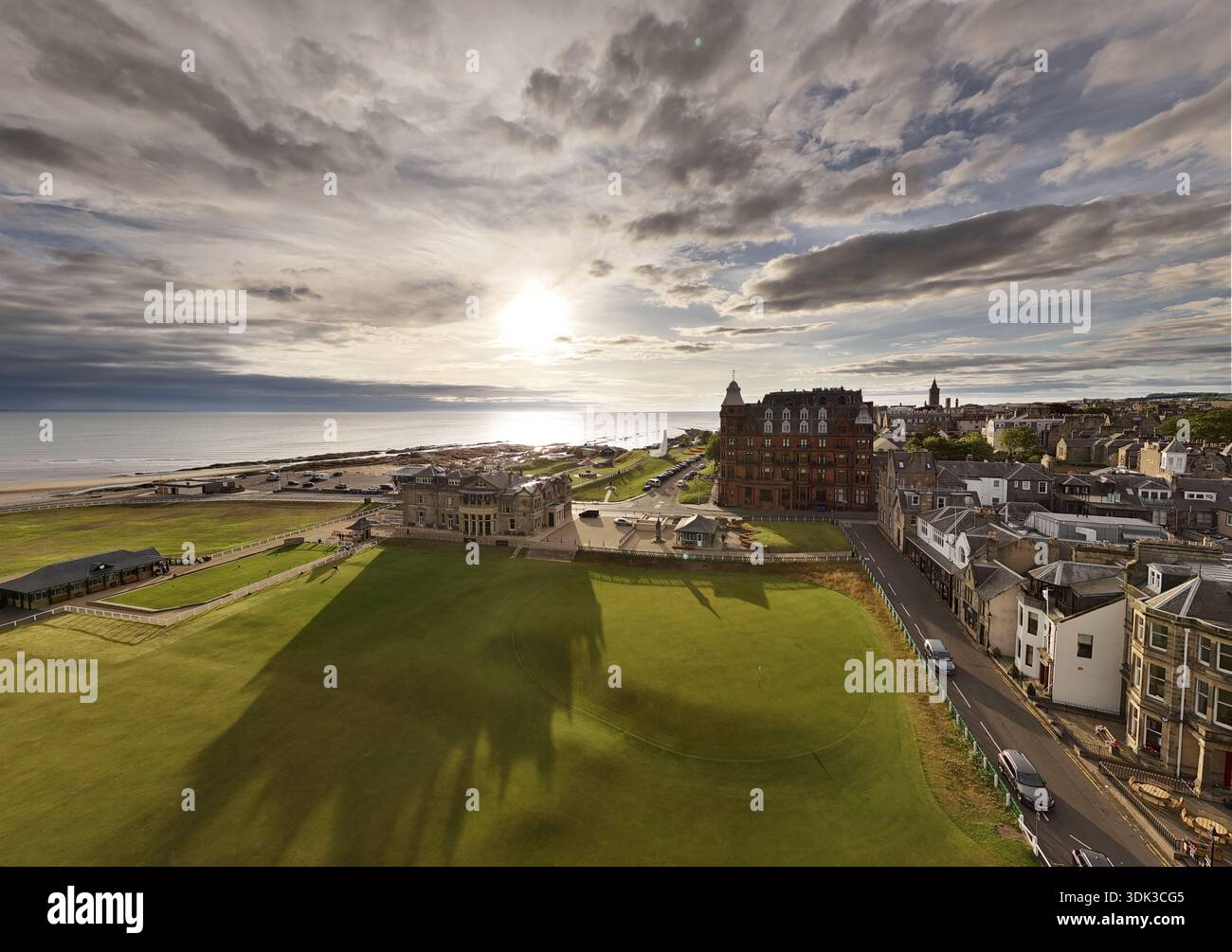 Vista aerea della luce del sole dorata che bacierà il verde curato del campo da golf, incontrando la costa frastagliata e gli edifici storici, St Andrews, SCO Foto Stock
