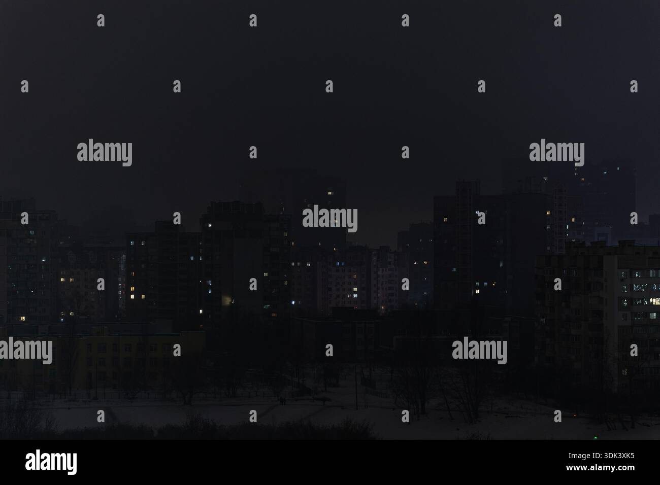 Quartiere residenziale a più piani di Kiev sotto blackout notturno totale. I grattacieli scuri hanno una silhouette senza elettricità in inverno. Visione concettuale di URBAN e Foto Stock
