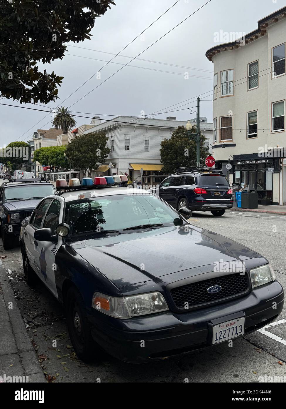 La pattuglia della polizia di San Francisco ha parcheggiato in una strada di quartiere sotto il cielo coperto. - Immagine stock catturata con smartphone