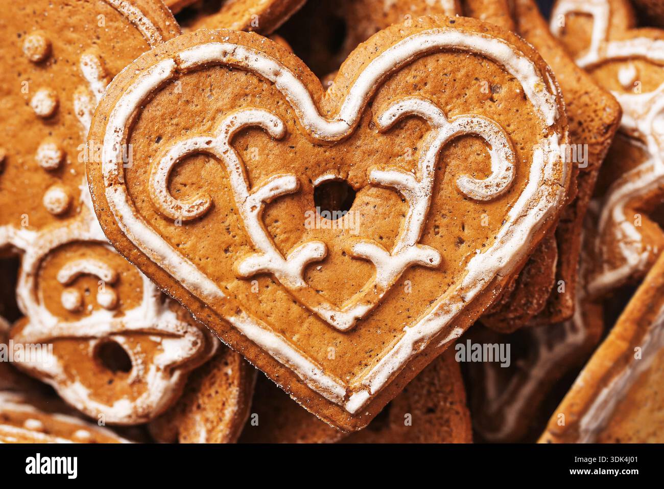 Biscotto al cuore di pan di zenzero con primo piano decorativo. Tradizionale dettaglio di cottura natalizia. Simbolo del dolce natalizio. Pasta dolce fatta a mano. Foto Stock