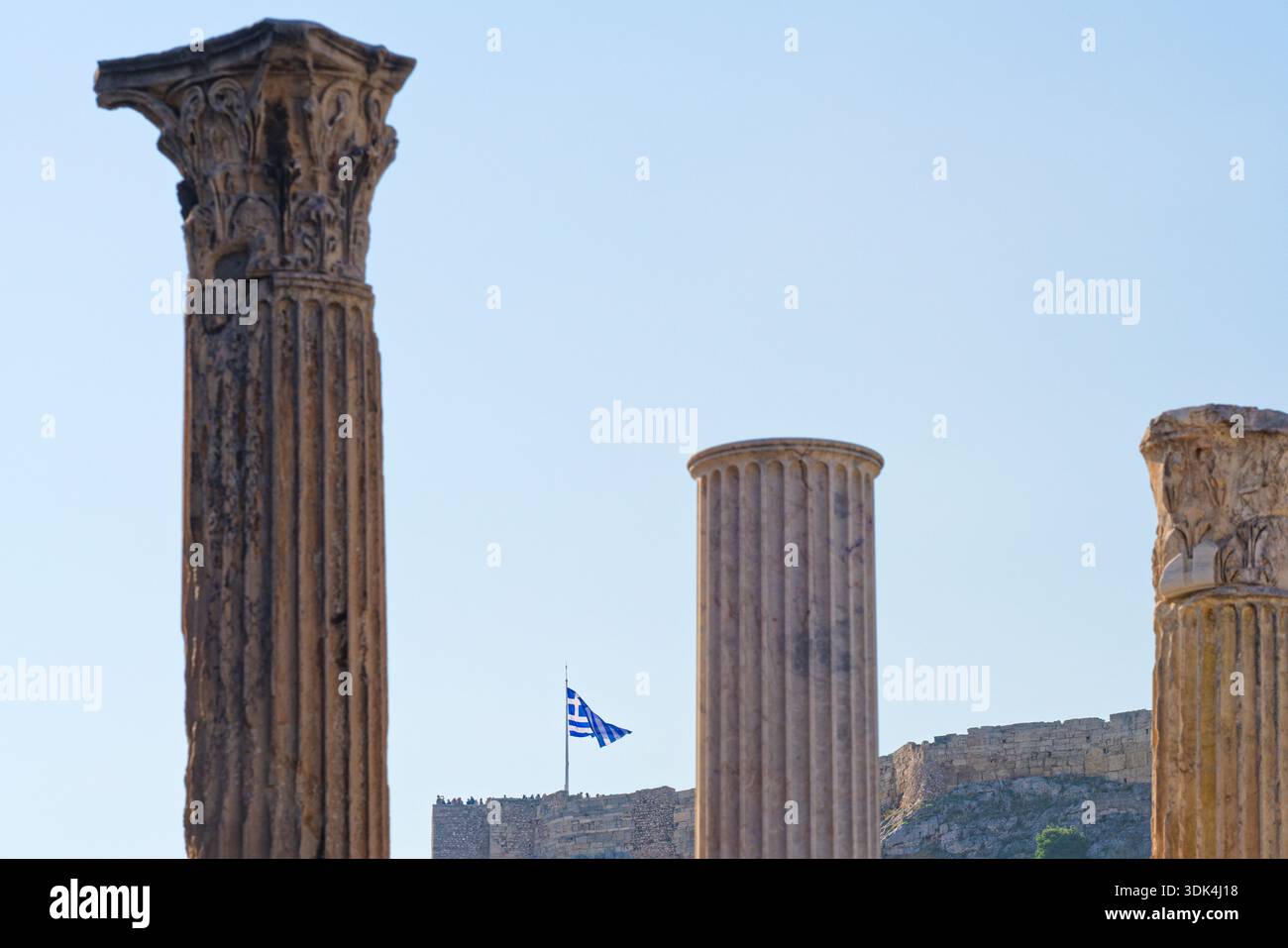 La bandiera nazionale tra le colonne dell'antica Agorà romana, centro di Atene, Grecia Foto Stock