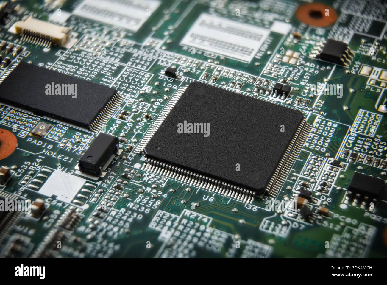 Primo piano di una scheda a circuito stampato che mostra microchip, componenti saldati e tracce di circuiti sottili, evidenziando l'elettronica avanzata e la moderna h Foto Stock