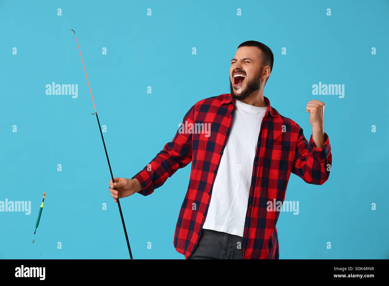 Giovane felice con canna da pesca su sfondo blu Foto Stock