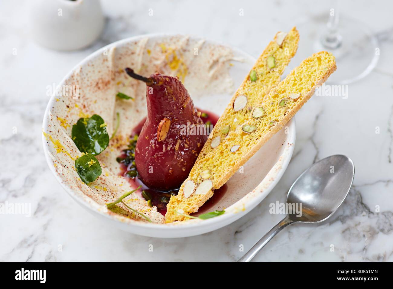 Pere di vino rosso in camicia con biscotti al pistacchio Foto Stock
