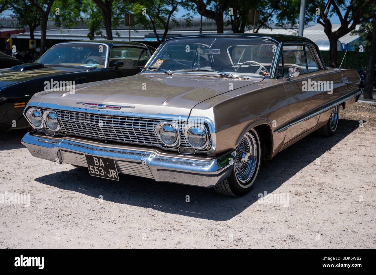Una splendida Chevrolet Impala del 1963 con finitura marrone metallizzato e griglia cromata, che mostra il suo iconico design classico americano in una mostra di auto Foto Stock