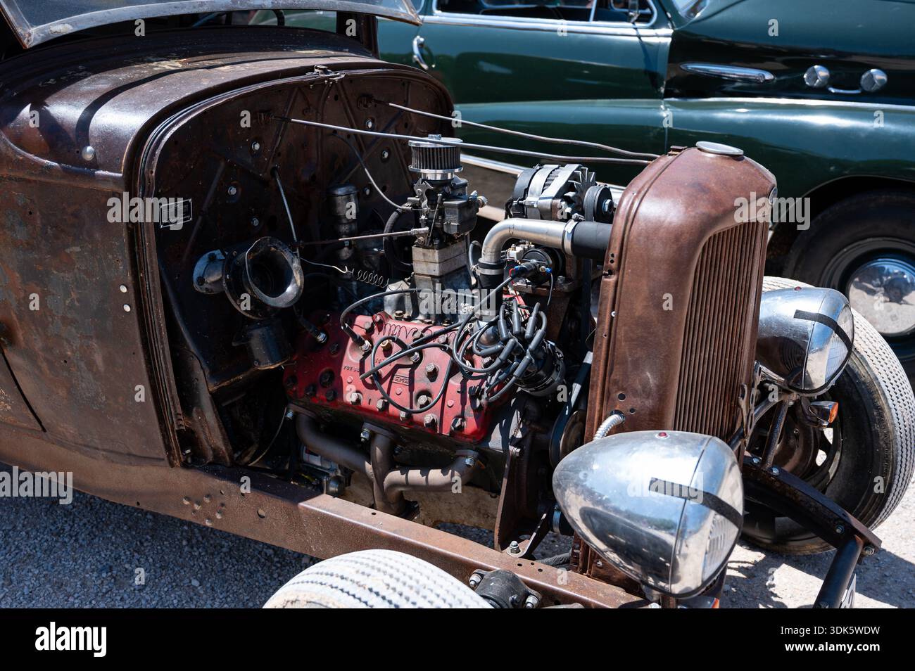 Un primo piano dettagliato di un motore Ford V8 a testa piatta arrugginito e modificato in un Rat Rod del 1932, che mostra la sua meccanica grezza e potente. Foto Stock