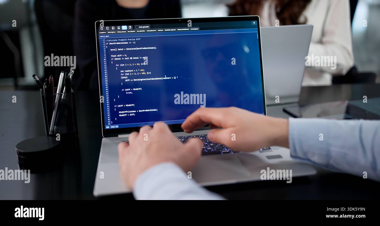 Team di codifica efficiente che sviluppa soluzioni software in diversi ambienti aziendali. Foto Stock