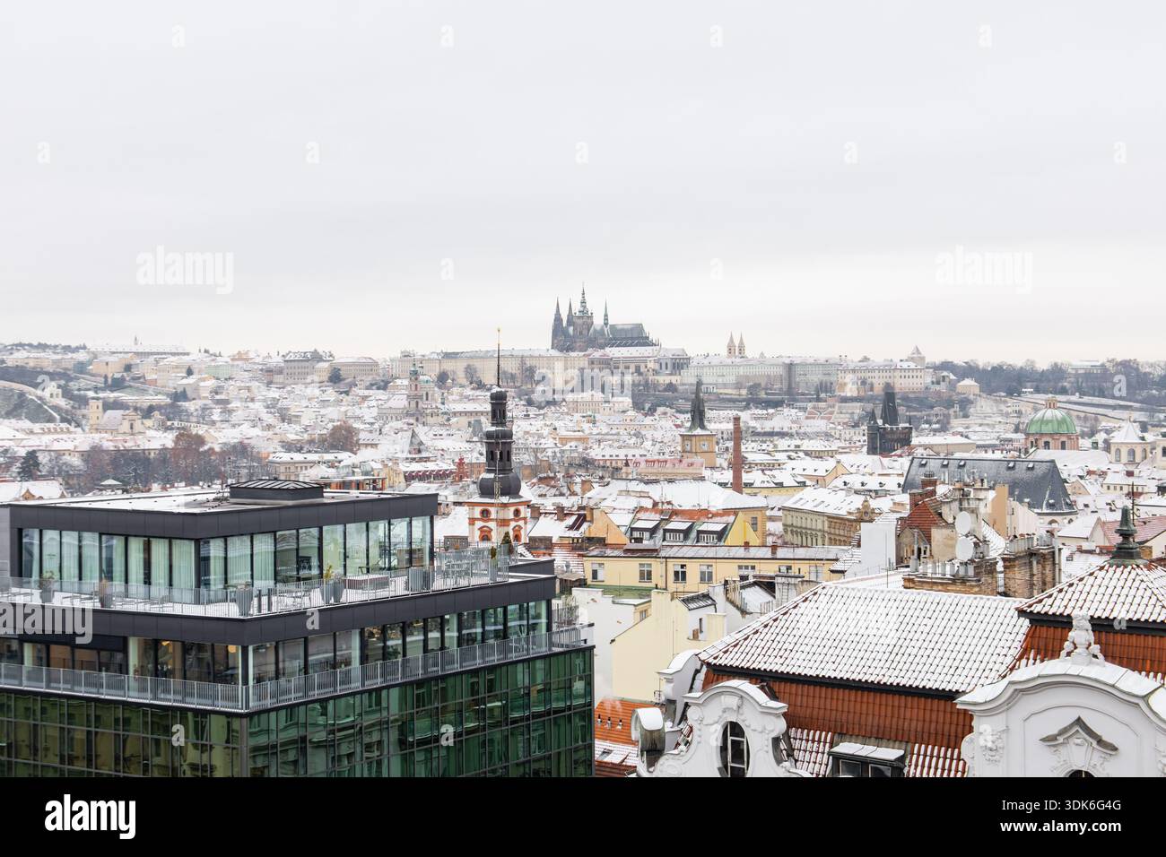 il panorama del castello di praga mostra la prima neve che copre i tetti storici Foto Stock