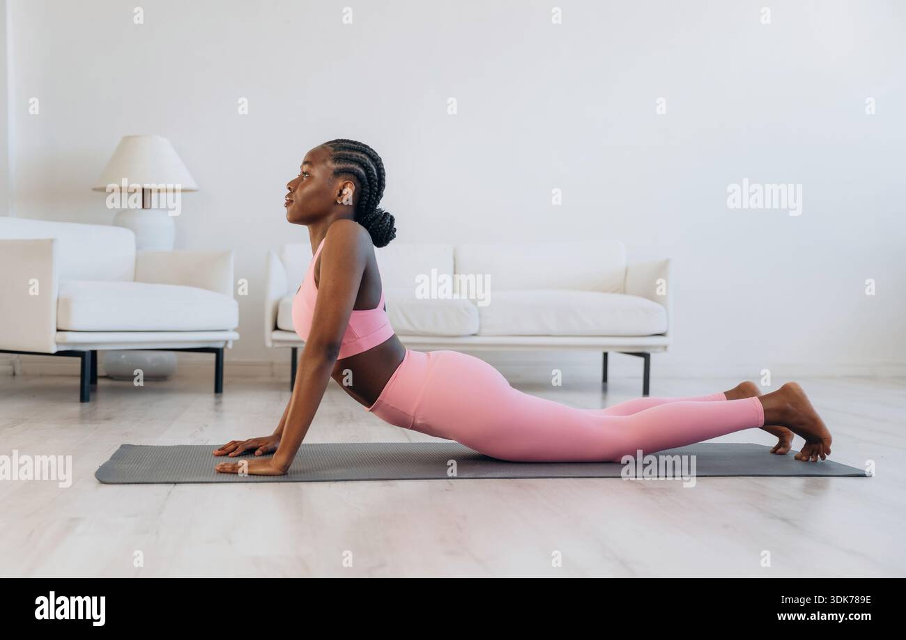 Esercizio della colonna vertebrale. La donna fa yoga a casa. Foto Stock