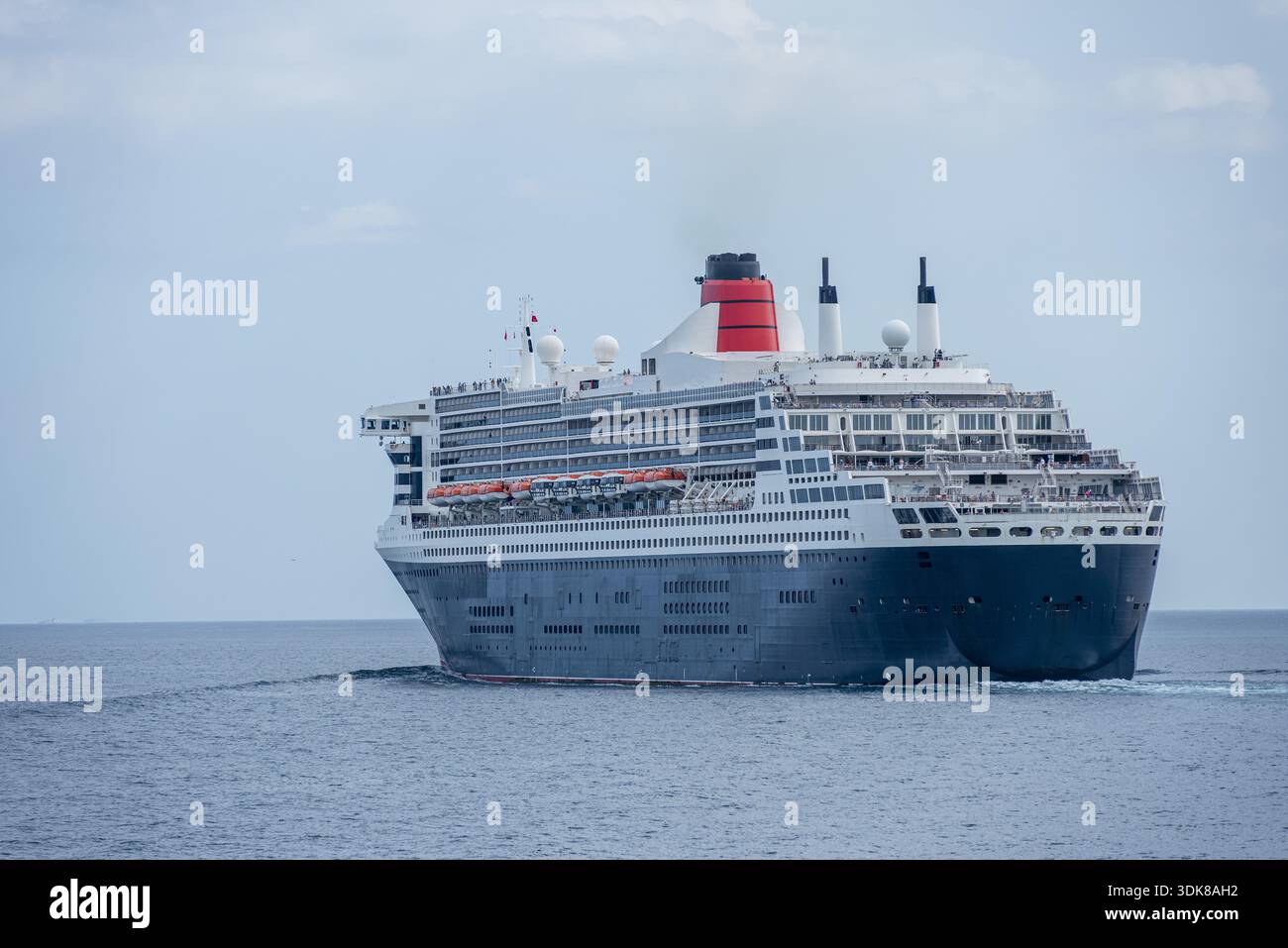 Nave da crociera di lusso vista da poppa mentre navighi sull'Oceano Pacifico sotto un cielo leggermente nuvoloso. Foto Stock