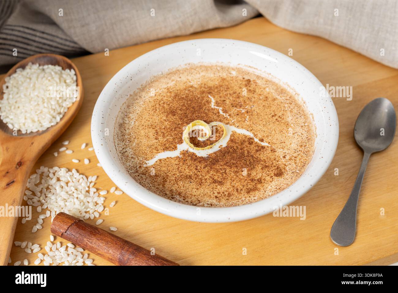 Budino di riso condito con cannella e scorza di limone in una ciotola bianca STILL Life Foto Stock