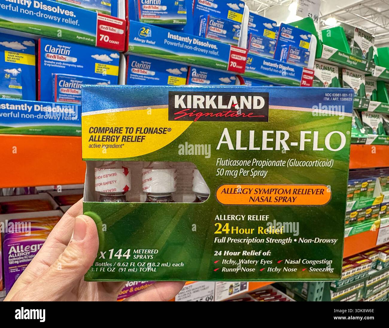Una mano che tiene in mano un contenitore di spray per naso Aller-Flo nella corsia per allergie di un negozio all'ingrosso Costco. Merrillville, Stati Uniti - 29 gennaio 2026 - Immagine stock catturata con smartphone