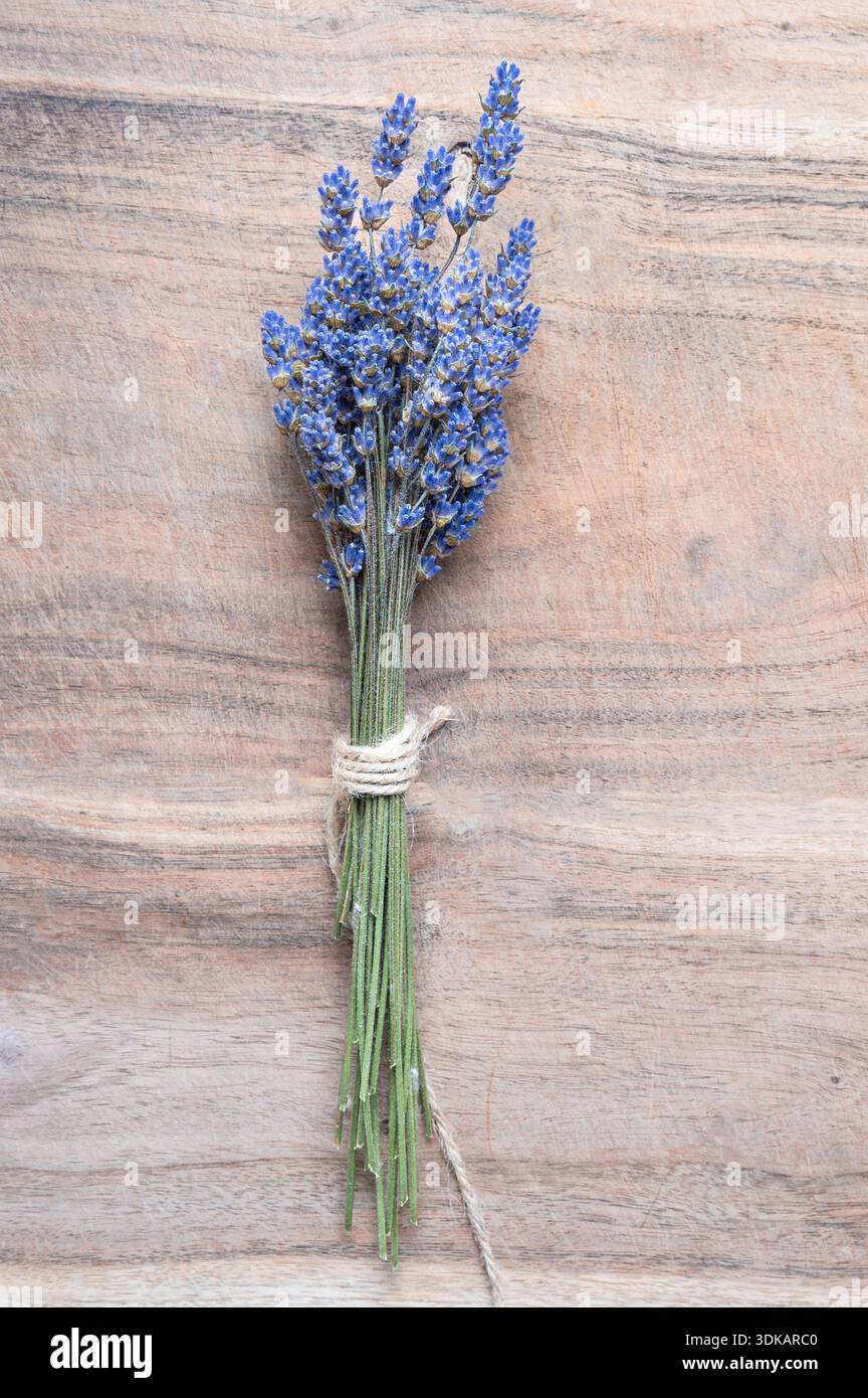 Un fascio di lavanda viola legato con spago su un tavolo di legno Foto Stock