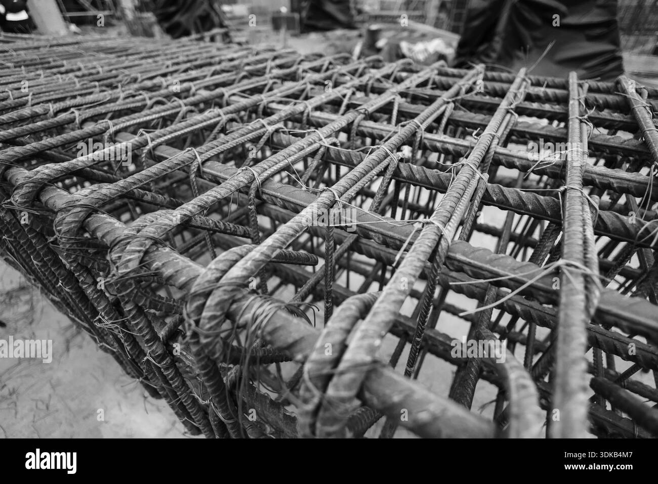 Dettagli della profondità di campo bassa (messa a fuoco selettiva) con barre di rinforzo (armature) in cantiere. Foto Stock