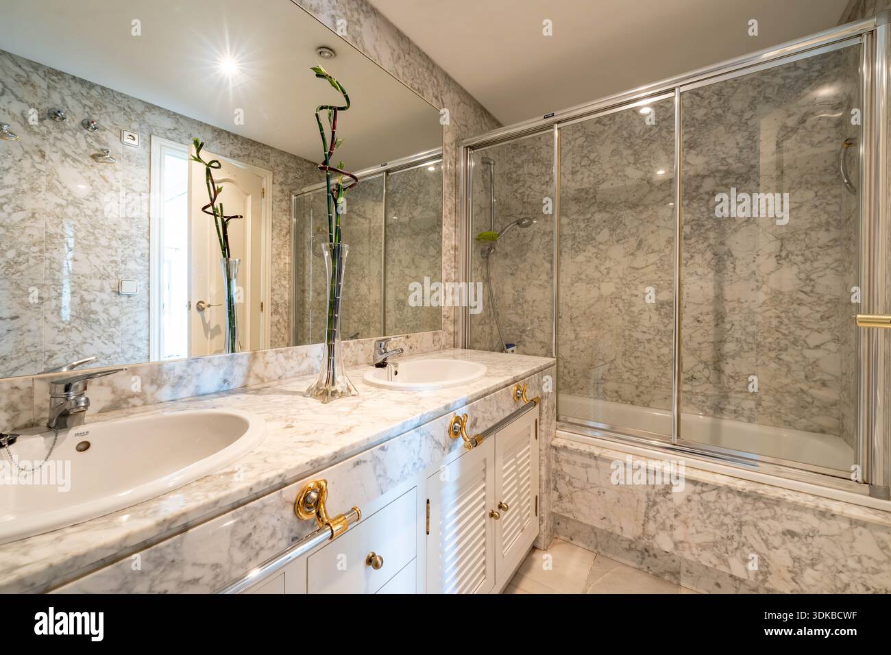 un'immagine di un lussuoso bagno in marmo con doppio lavandino e vasca completa Foto Stock