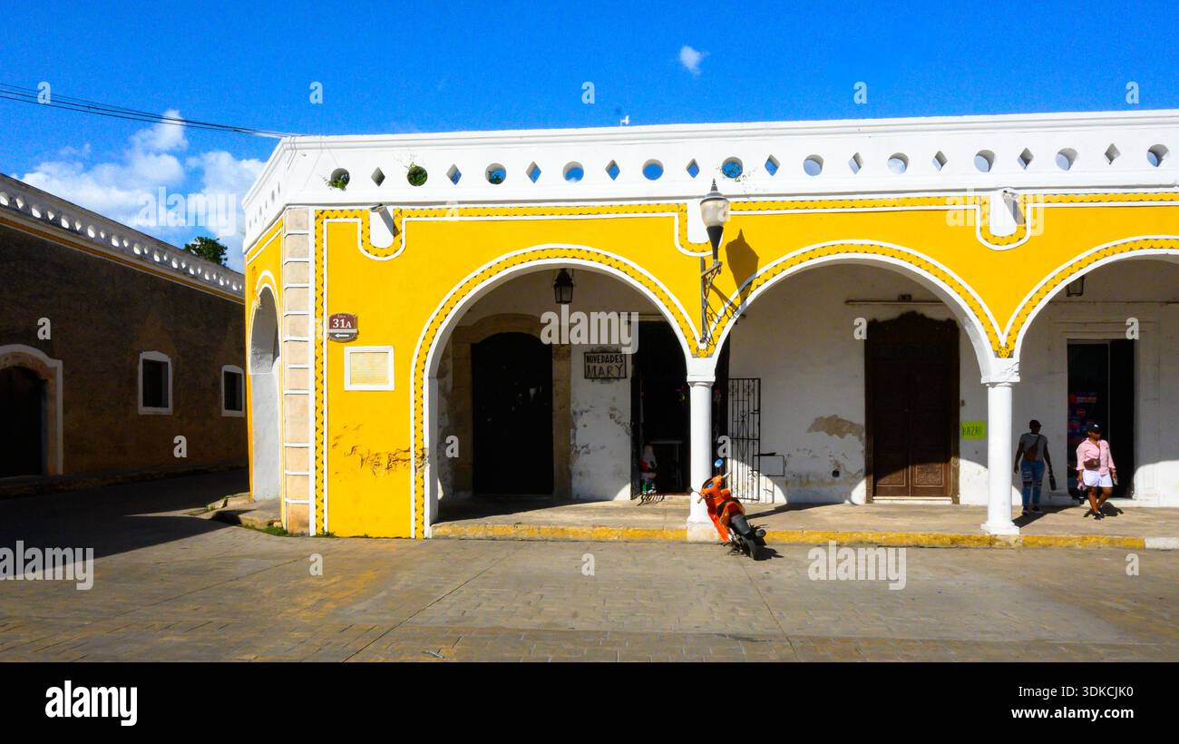Izamal, Yucatan, Messico - 26 dicembre 2025, paesaggio urbano di Izamal con pedoni e strade storiche gialle Foto Stock