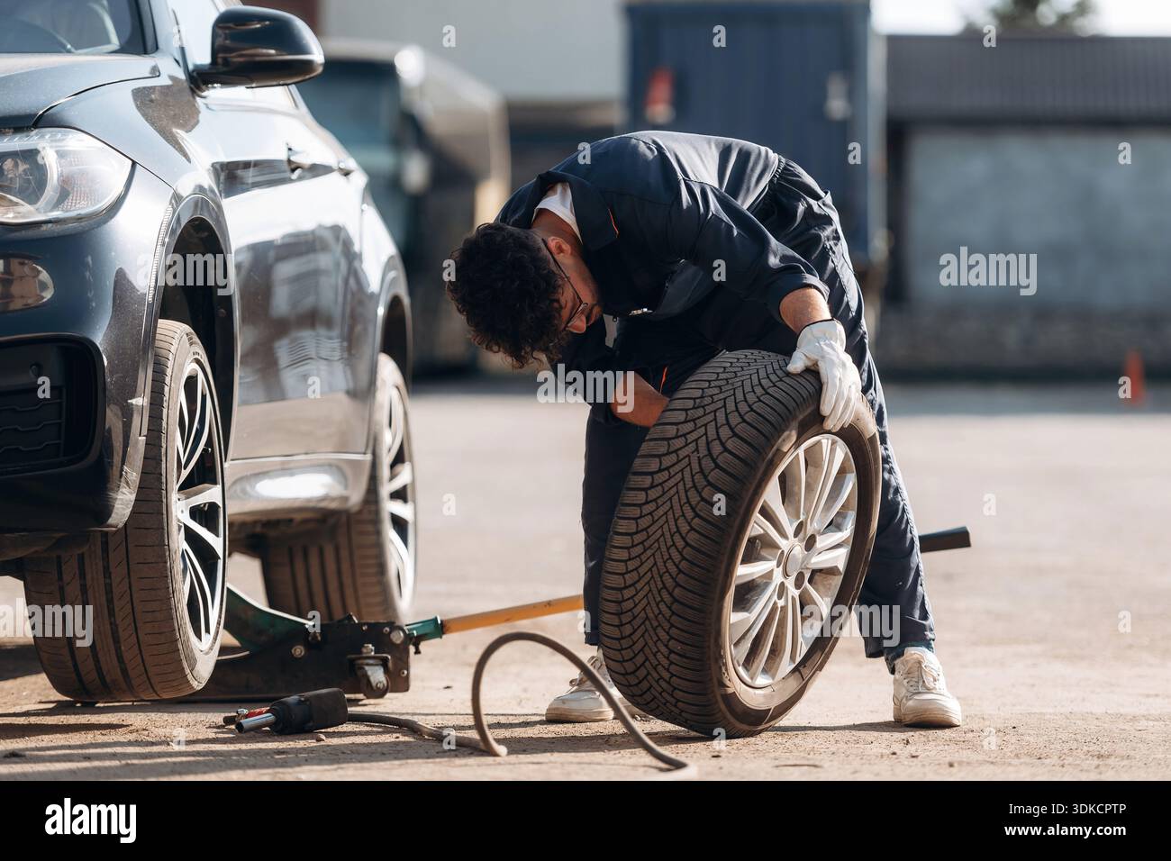 Il meccanico è con l'auto all'aperto. Foto Stock