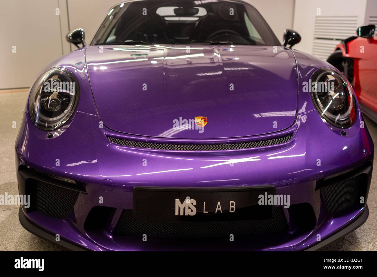Primo piano anteriore Porsche viola con vernice personalizzata lucida e paraurti aggressivo, piastra DA LABORATORIO MS visibile, Showroom Warsaw, Polonia 29-01-2026 Foto Stock