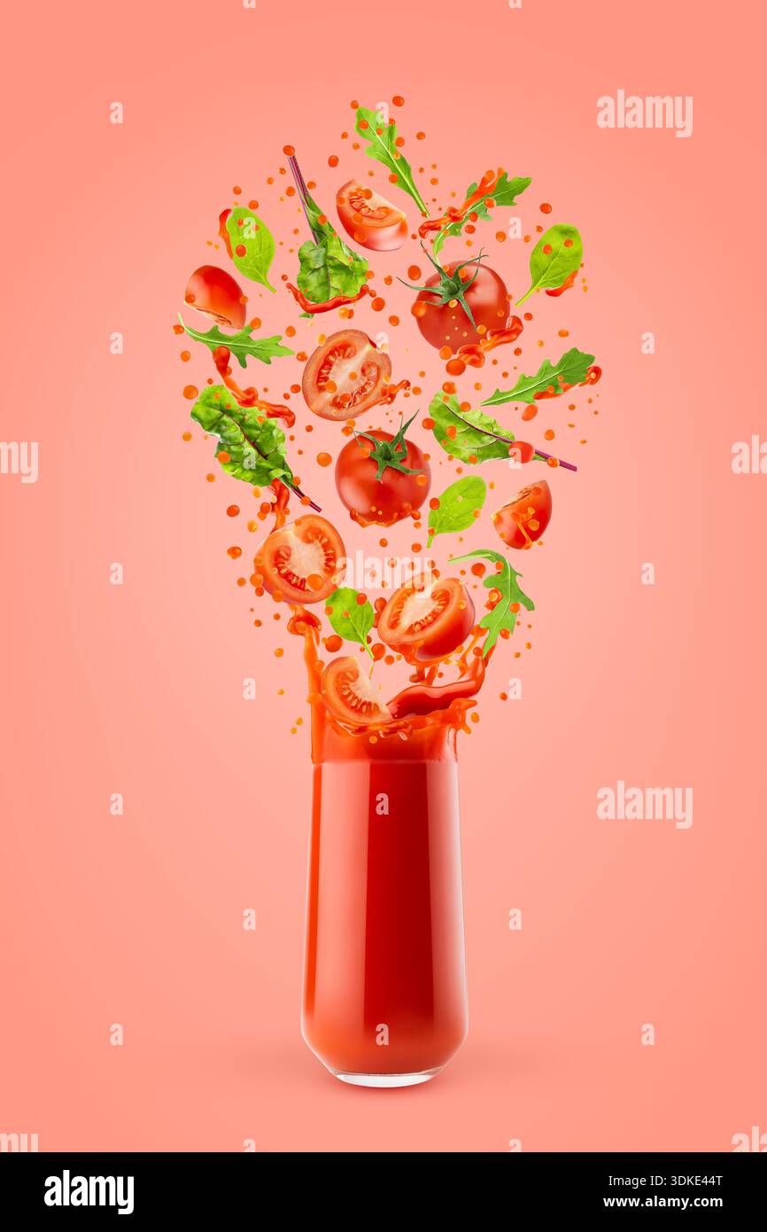 Succo di verdure rosse in vetro con pomodori volanti, verdure, spinaci verdi, schizzi e flussi di succo su sfondo rosa. Frullato di verdure per la guarigione Foto Stock