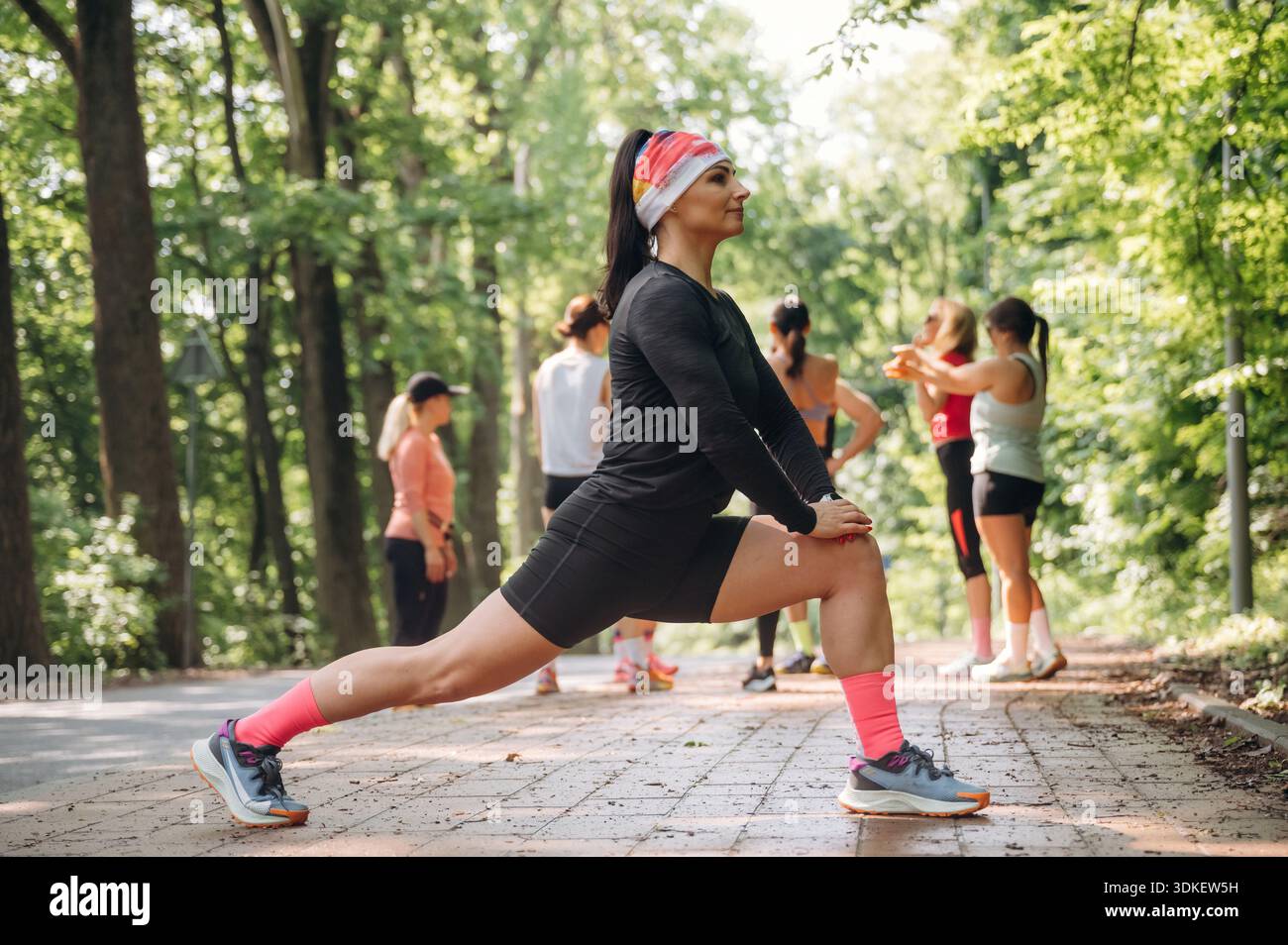 Prepararsi per la maratona facendo esercizi caldi. Un gruppo di corridori si trova all'aperto. Foto Stock