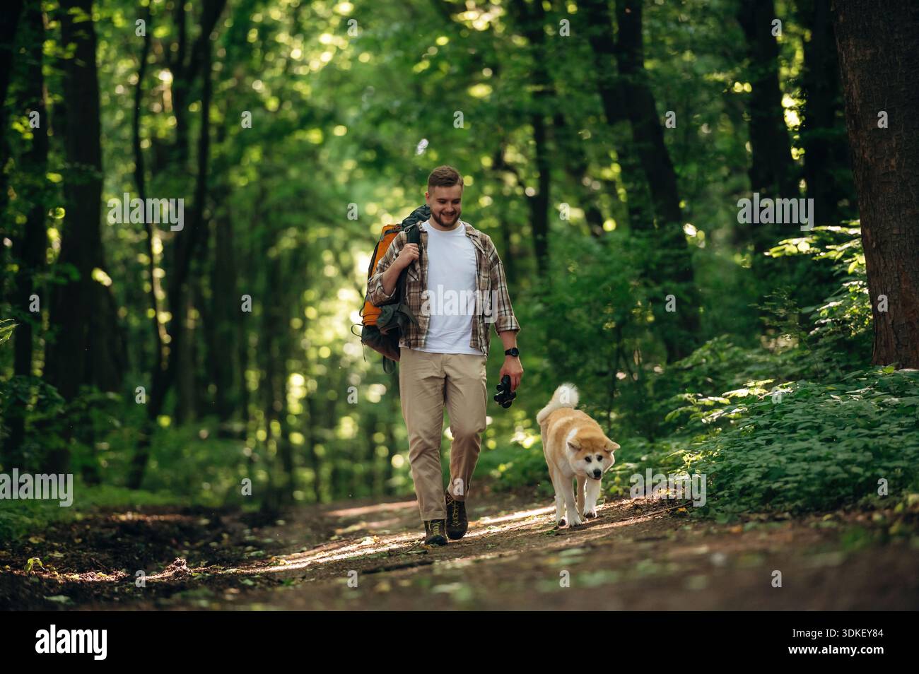 Nuovi posti, esplorare, camminare, vista frontale. L'uomo turista è con il suo cane nella foresta. Foto Stock