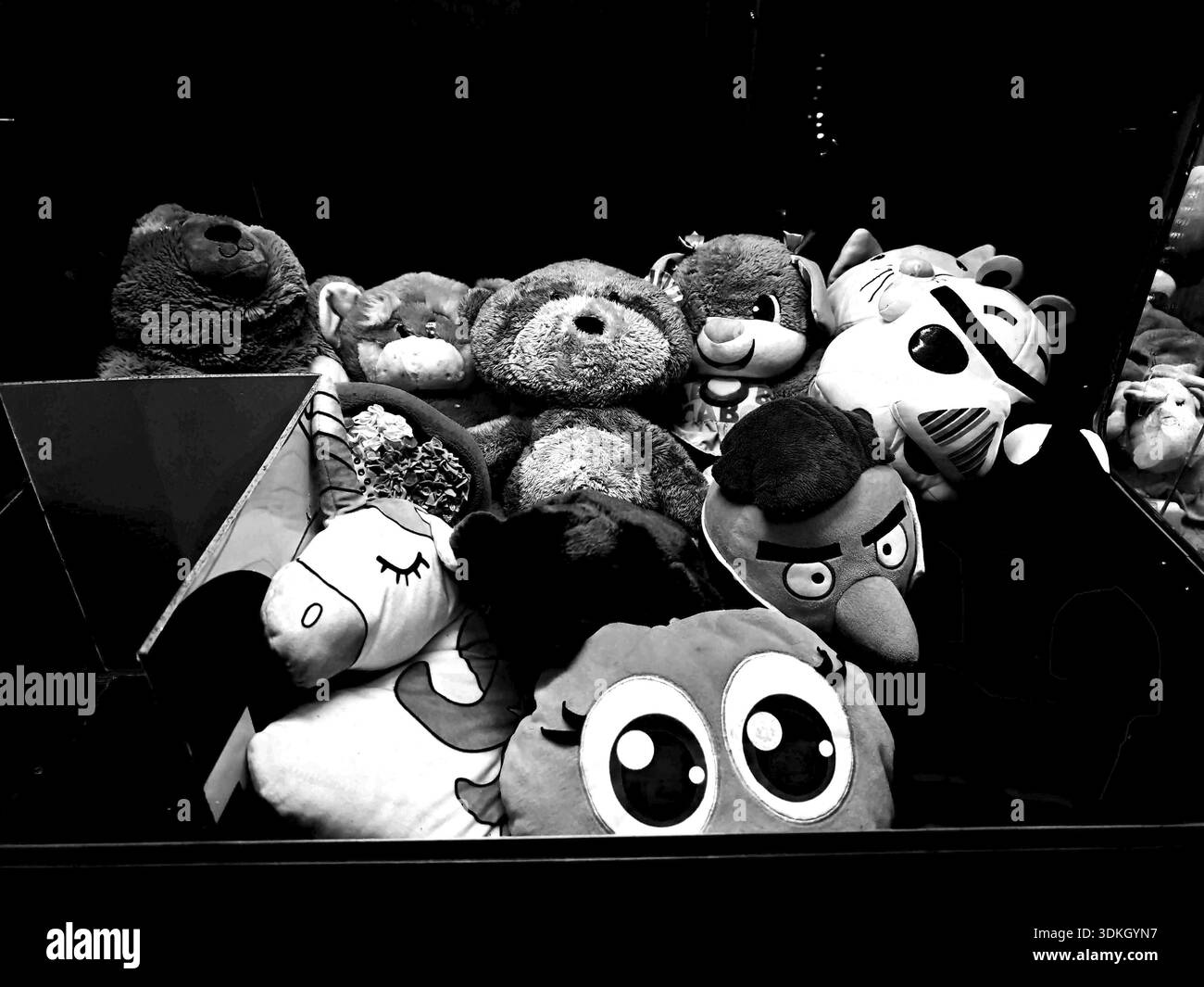 Collezione di vari animali farciti in un ambiente buio, foto in bianco e nero di un distributore automatico di giocattoli, Claw machine, Batumi, Georgia Foto Stock
