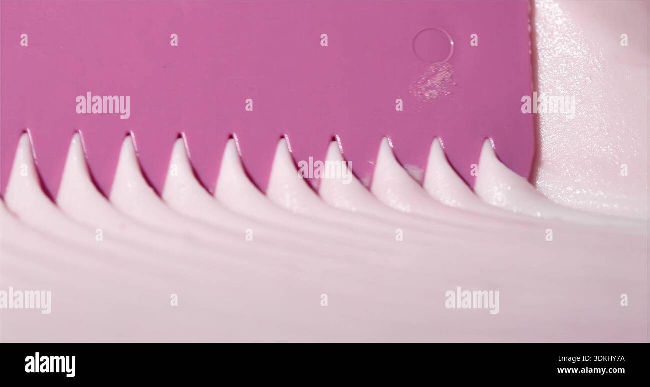 Foto macro che evidenziano bordi con ghiaccio liscio e finitura lucida su superficie rosa brillante Foto Stock