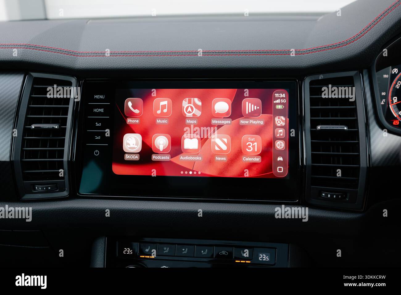 Primo piano del sistema di informazione e intrattenimento Apple CarPlay visualizzato su un moderno cruscotto dell'auto che mostra la musica e i messaggi di navigazione per consentire la guida connessa Foto Stock