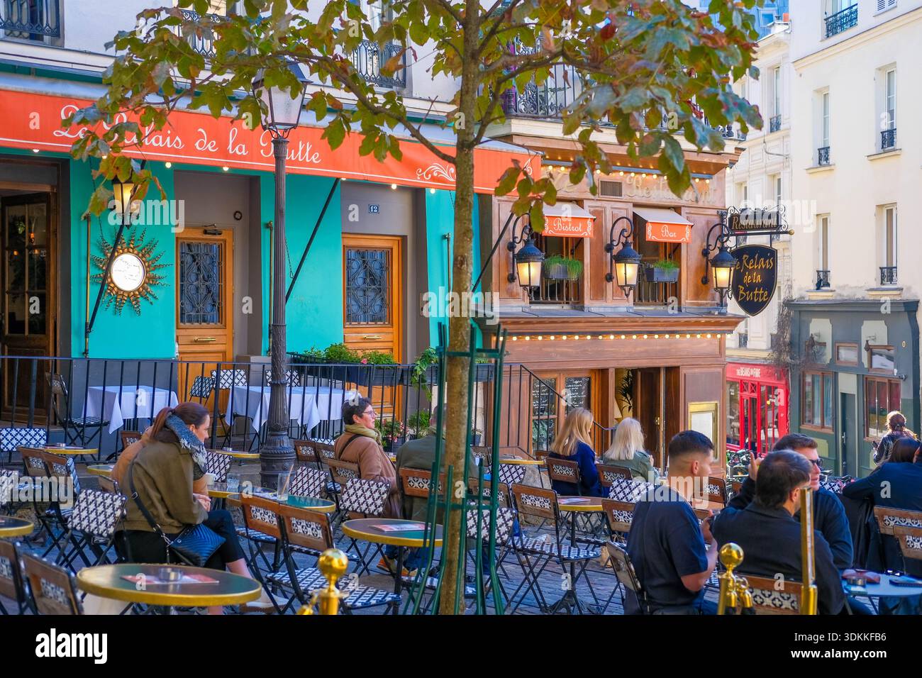 Parigi, Francia - 09.28.2025: Caffè le Relais de la Butte, tavoli all'aperto su Montmartre. Viaggiando in Europa, camminando attraverso Parigi, giornata calda in terrazza Foto Stock