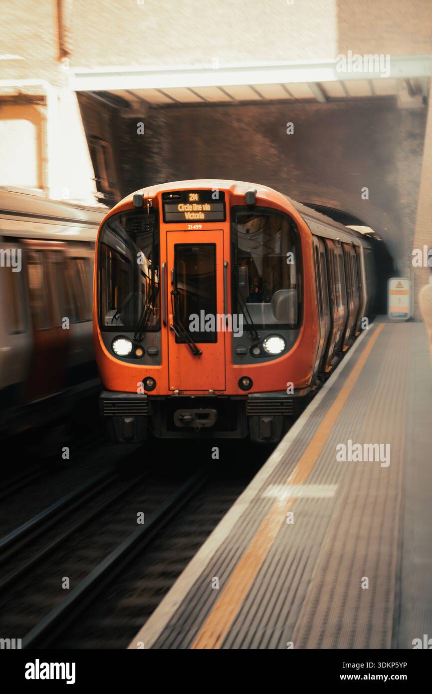 Un'auto della metropolitana accelera attraverso la metropolitana o la metropolitana di Londra fornendo mezzi di trasporto pubblici efficienti e affidabili in tutta l'area metropolitana di Londra. Foto Stock