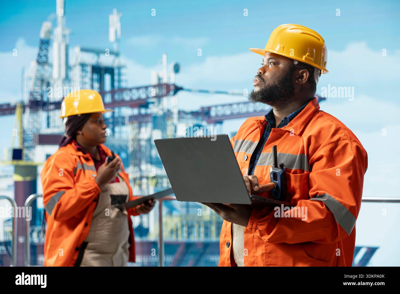 I colleghi della piattaforma offshore supervisionano le operazioni del ponte con un notebook, garantendo la conformità ai protocolli di sicurezza. Team tecnico che esegue la manutenzione preventiva dell'attrezzatura per perforazioni Foto Stock