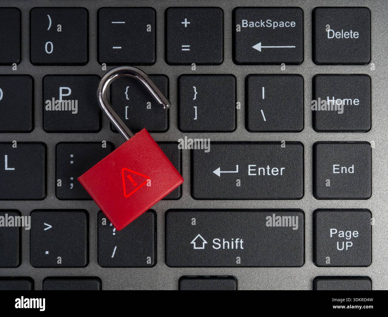 Lucchetto rosso sbloccato con simbolo di avvertimento su sfondo nero della tastiera del computer. Concetto di minacce alla sicurezza informatica, violazione dei dati, fuga di password e onli Foto Stock