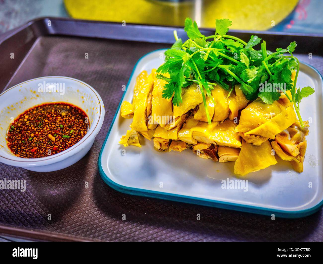Il caratteristico pollo Golden Three-Yellow Chicken di Shanghai Yixinzhai presenta carne tenera e pelle dorata, servito con salsa piccante di olio rosso Foto Stock