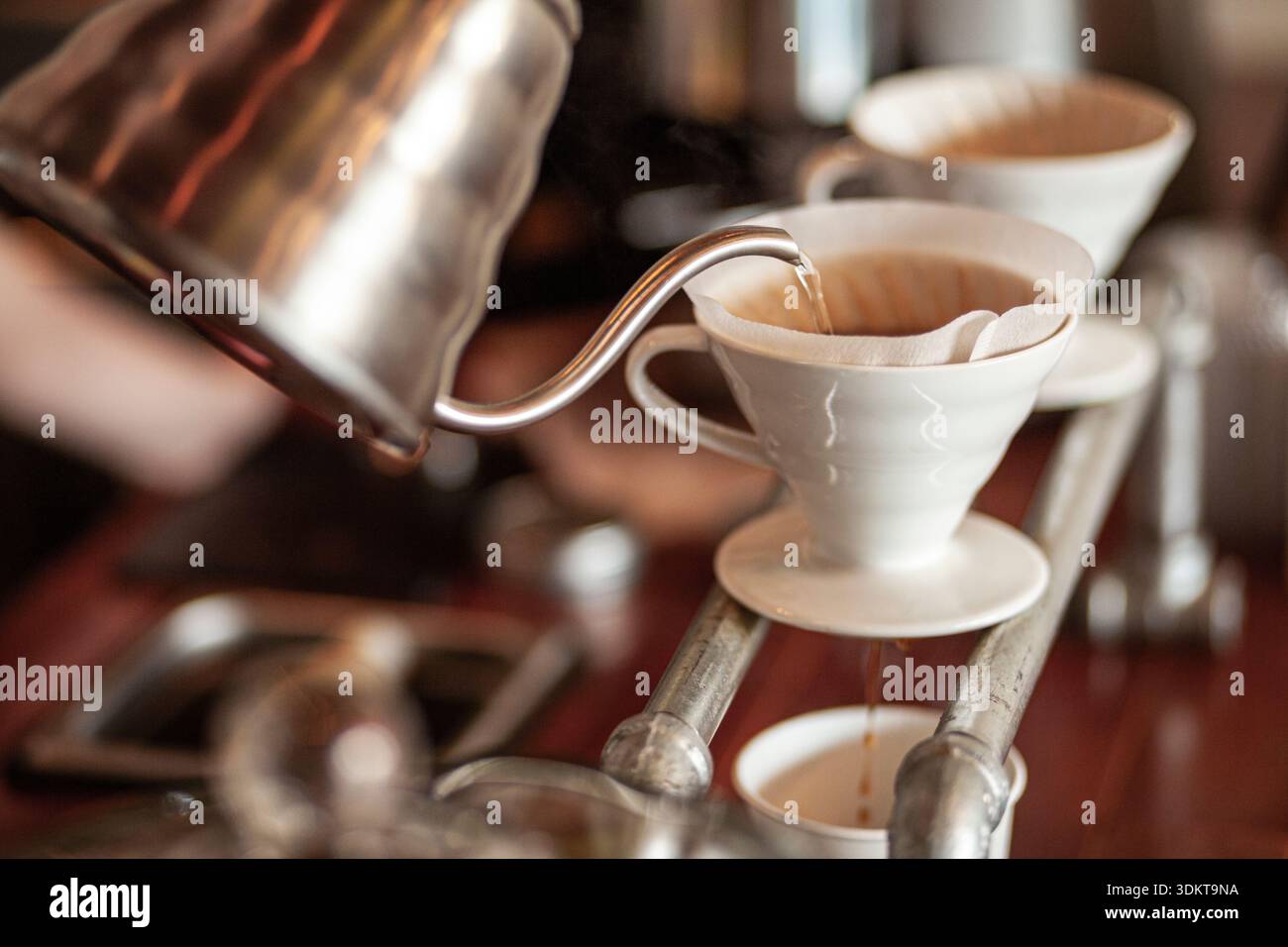 Bollitore che versa acqua su caffè speciale nel filtro v60 Foto Stock