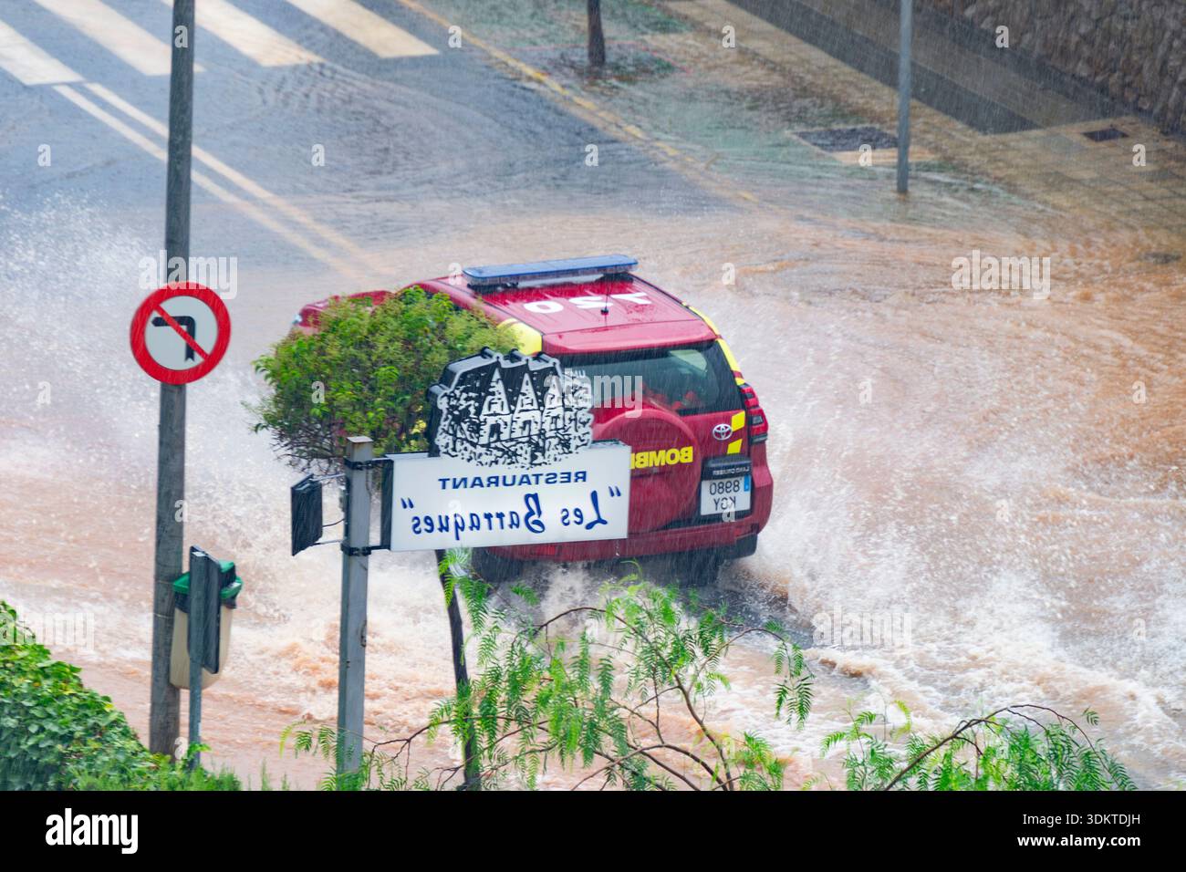 Strade urbane inondate di acqua che trabocca dagli scarichi quando le persone liberano le acque alluvionali e i veicoli si spostano attraverso le aree colpite dopo una pioggia intensa. Spagna. Foto Stock