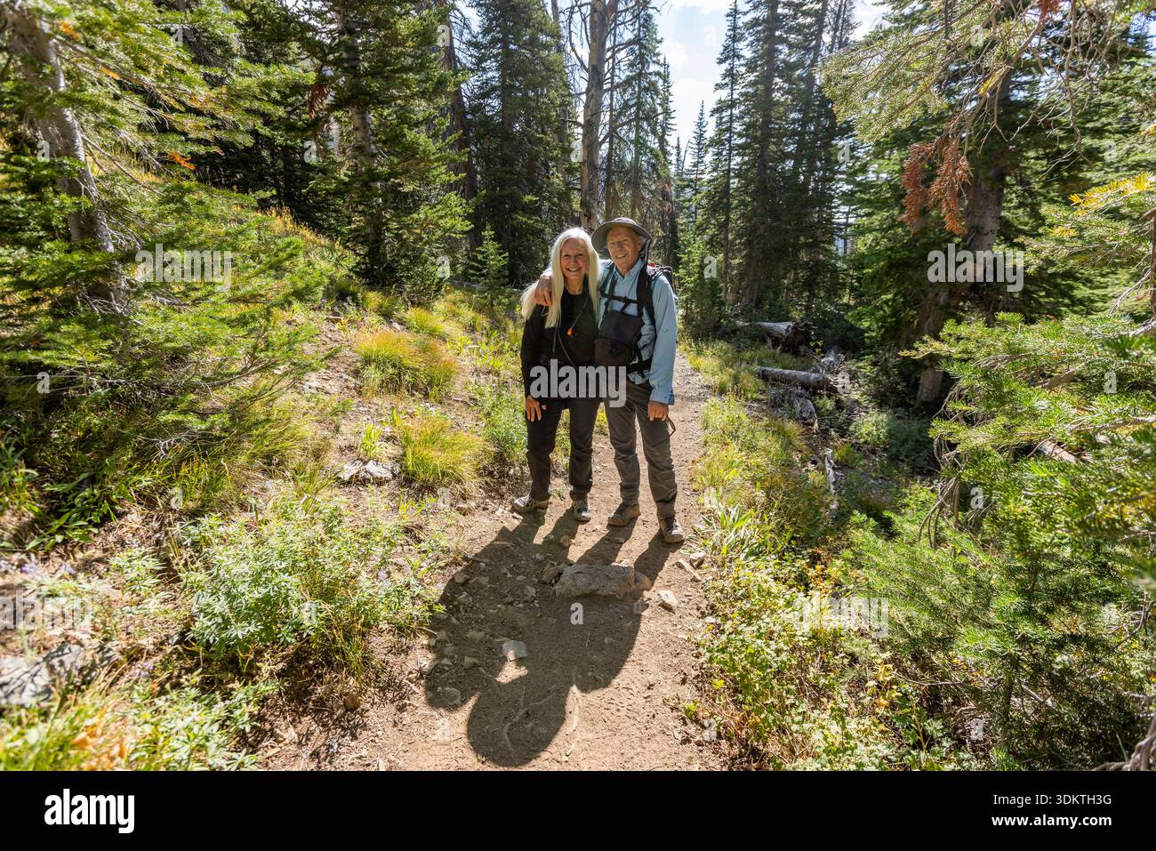 USA, Idaho, Sun Valley, Ritratto di coppia sorridente in piedi su un sentiero nella foresta Foto Stock