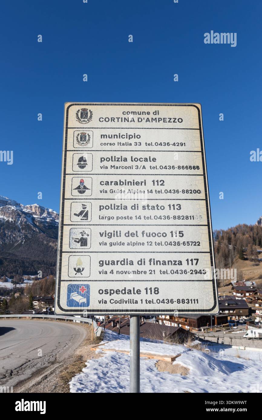 Cartello segnaletico stradale con elenco di diversi servizi pubblici e contatti di emergenza - Cortina d'Ampezzo, Veneto, Italia Foto Stock