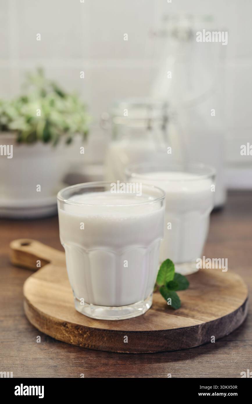 Due bicchieri di bevanda tradizionale turca ayran, kefir o latticello, yogurt bianco fatto in casa da vicino su un tavolo di legno Foto Stock