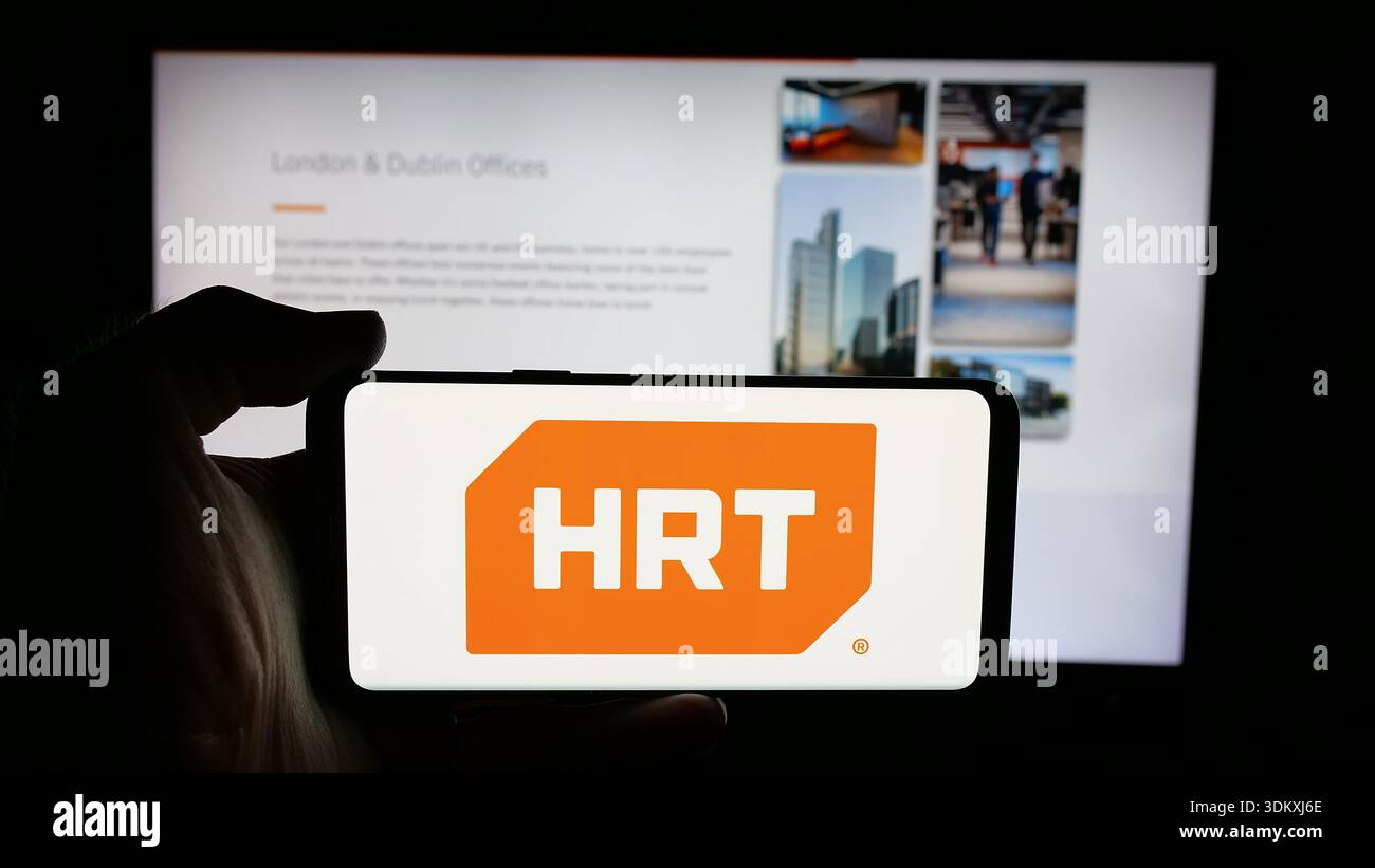 Stoccarda, Germania - 01-30-2026: Persona che detiene il cellulare con il logo della società statunitense Hudson River Trading LLC (HRT) sullo schermo davanti alla pagina web. Foto Stock
