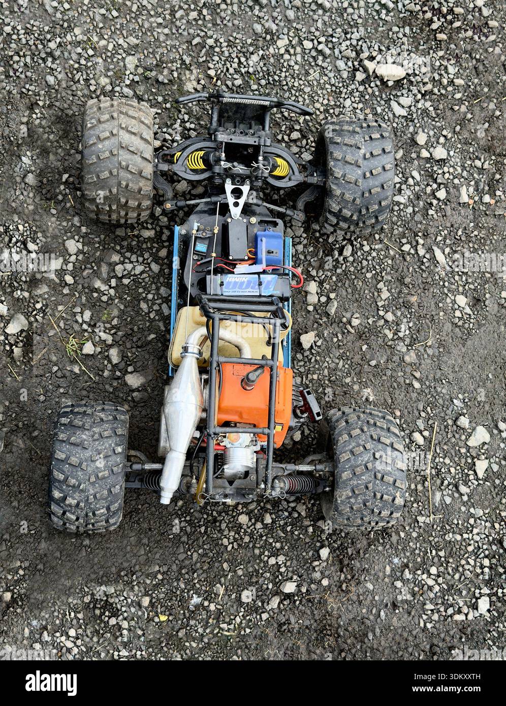 Vista dall'alto di un'auto telecomandata appoggiata su una superficie ghiaia, che mostra dettagli complessi dei suoi componenti Foto Stock
